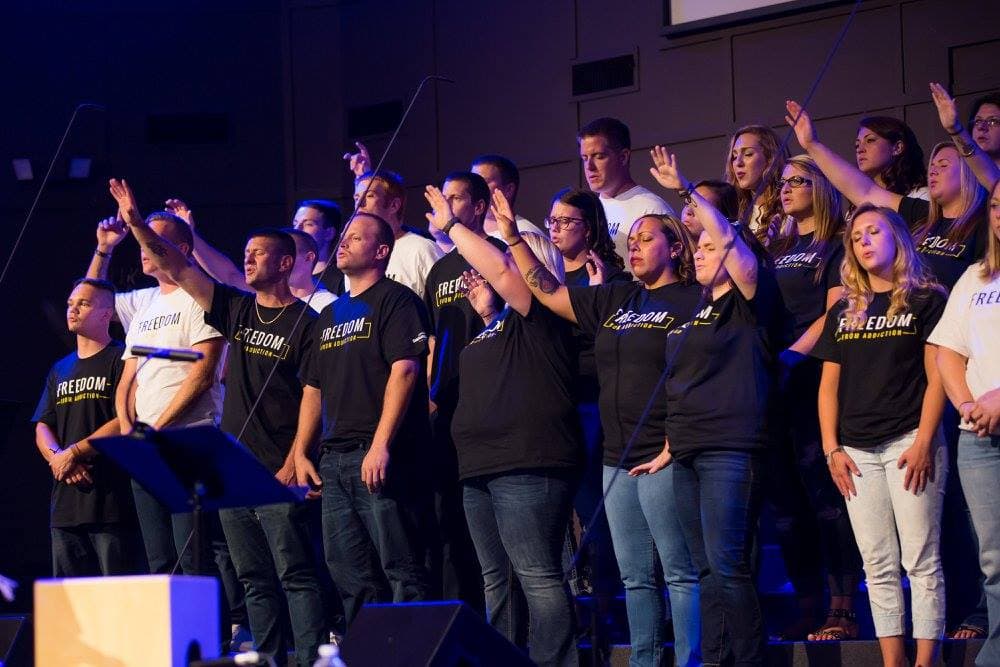 Hands raised in worship at a Shenandoah Valley Teen Challenge event