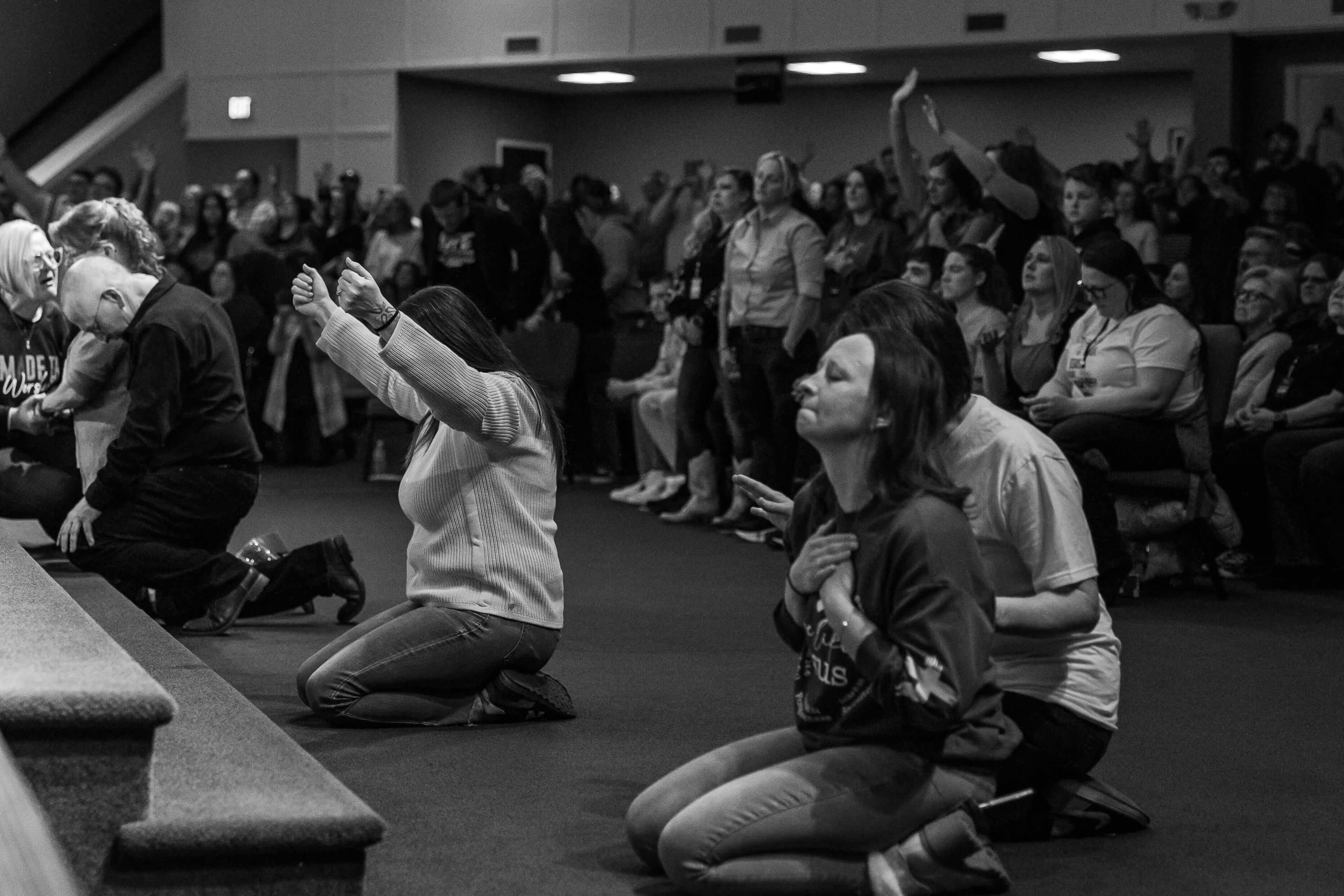 People in worship and prayer at a recovery event
